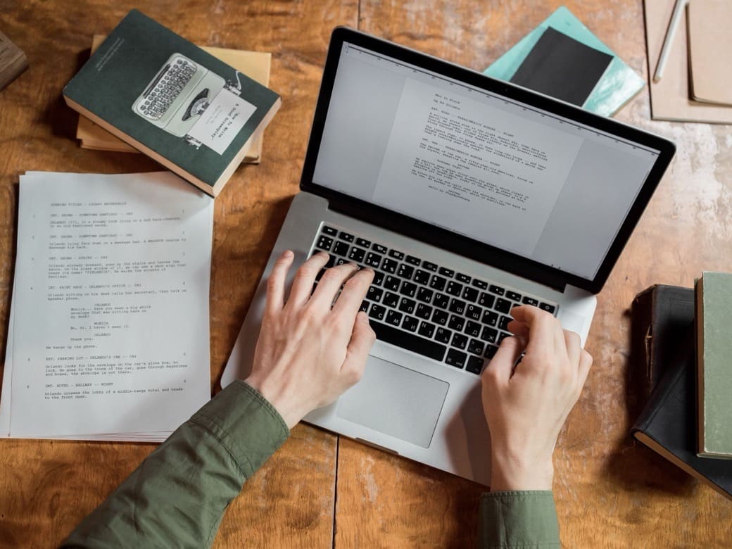Writing at a laptop, the work this system now does in minutes